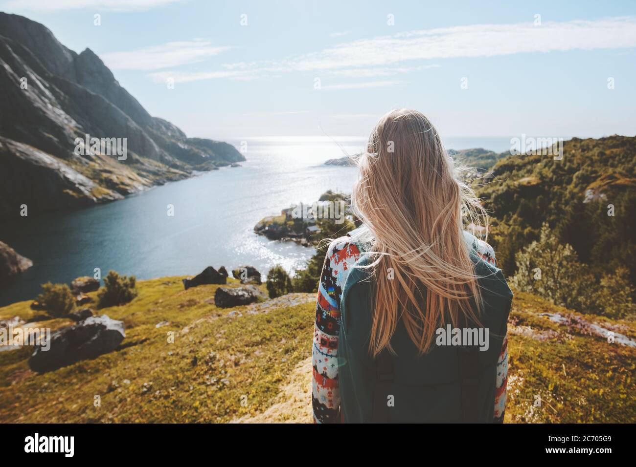 Woman traveler walking alone enjoying sea view outdoor travel summer vacations healthy lifestyle girl with backpack in Norway Stock Photo