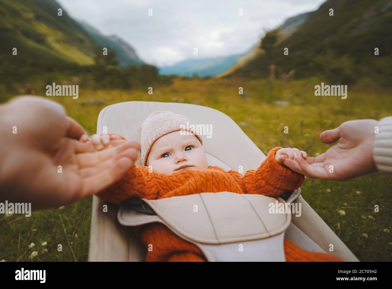 Baby infant in bouncer outdoor family travel lifestyle mother and father holding child hands summer vacations together Stock Photo