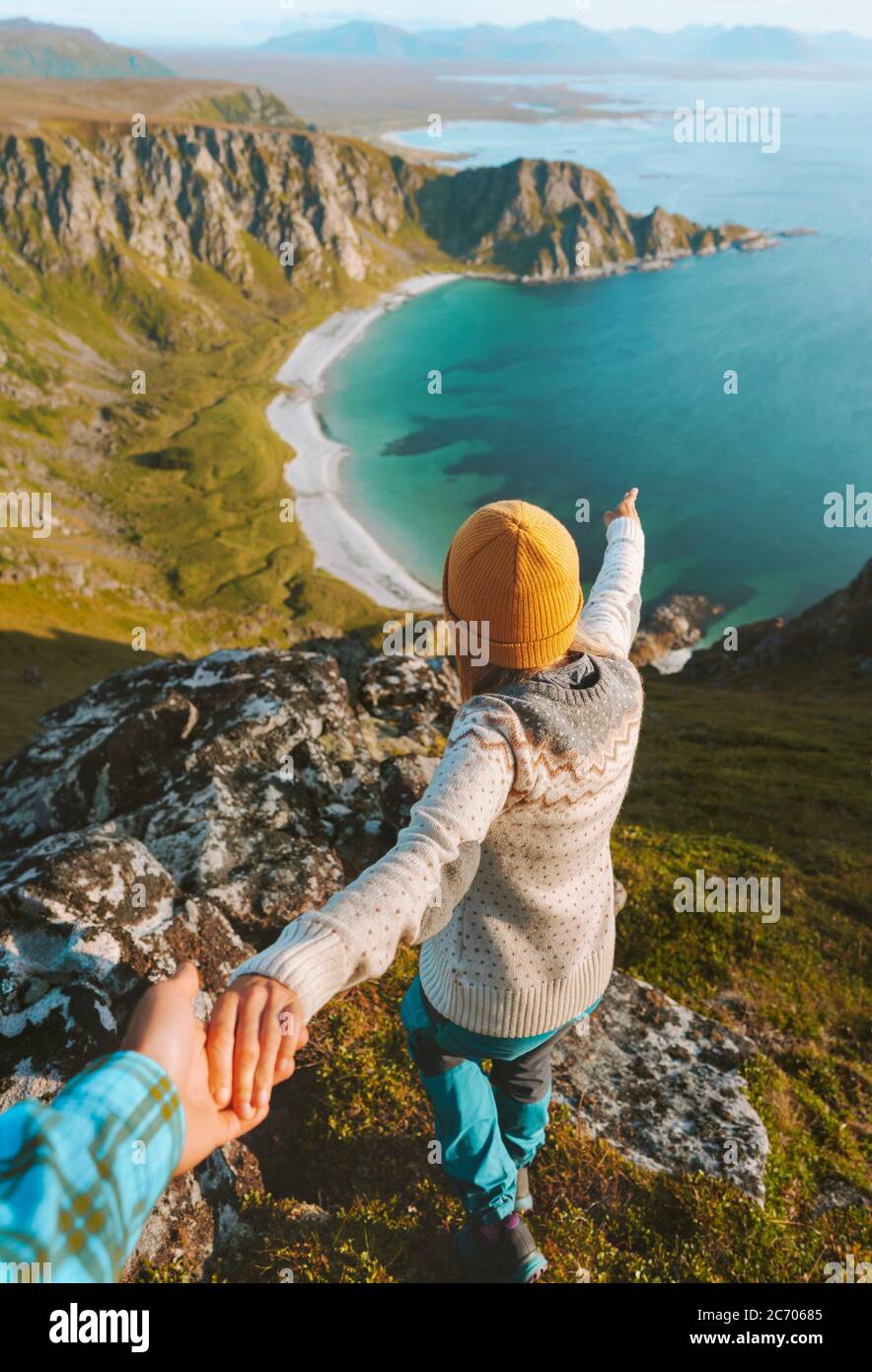 Couple traveling in Norway follow holding hands enjoying ocean beach aerial view  adventure lifestyle outdoor summer scandinavian vacations explore Ve Stock Photo
