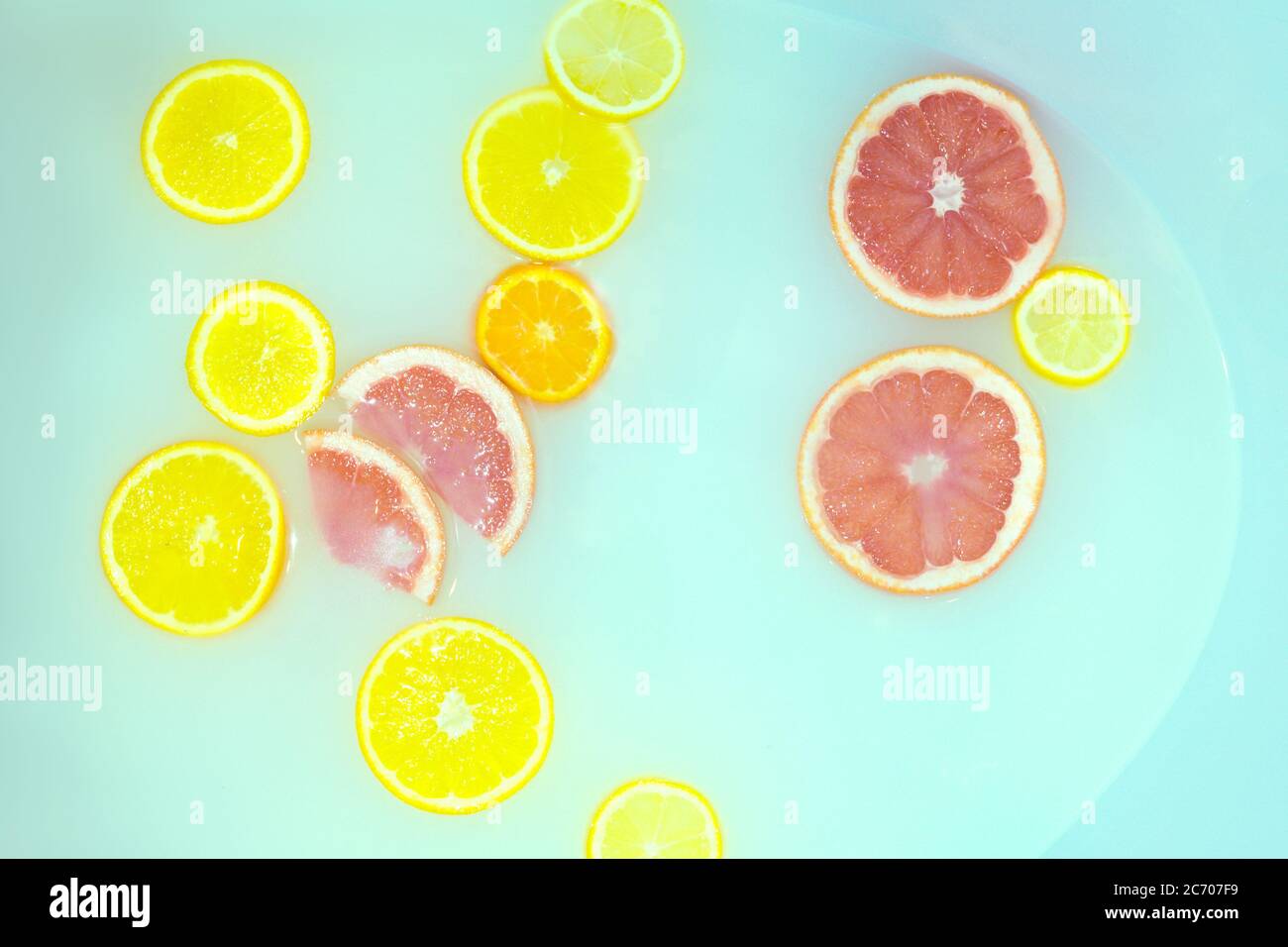 Milk bath with grapefruit, lemon and oranges slices. Top view. Flat lay