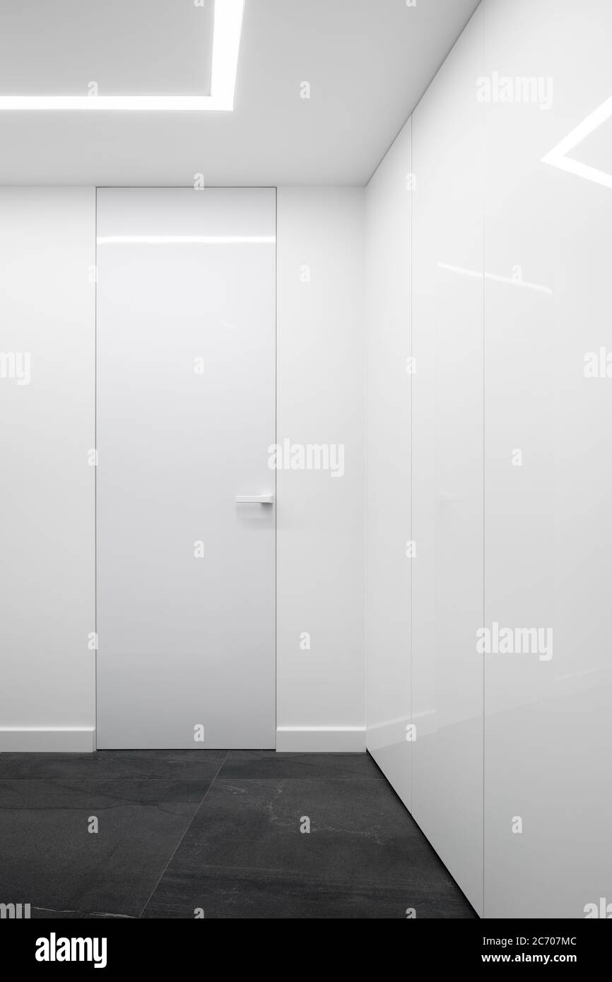 White, corridor interior with led ceiling light and tall white doors Stock Photo