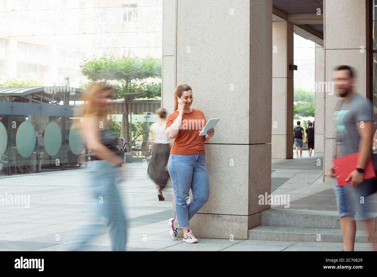 Working with gadgets. Caucasian inclusive plus-size model in daily routine. Realness, tolerance. Her lifestyle is the same like of other people. Concept of wellness, inclusion, diversity, human rights. Stock Photo