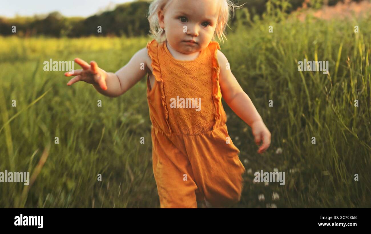 Child girl walking outdoor cute baby family travel vacations summer season nature rural field grass Stock Photo