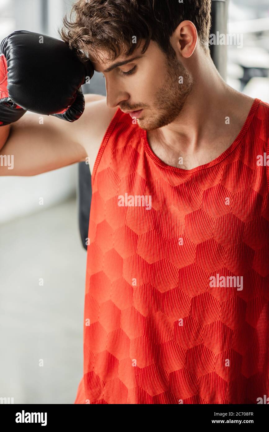 exhausted man in sportswear and boxing glove touching face Stock Photo