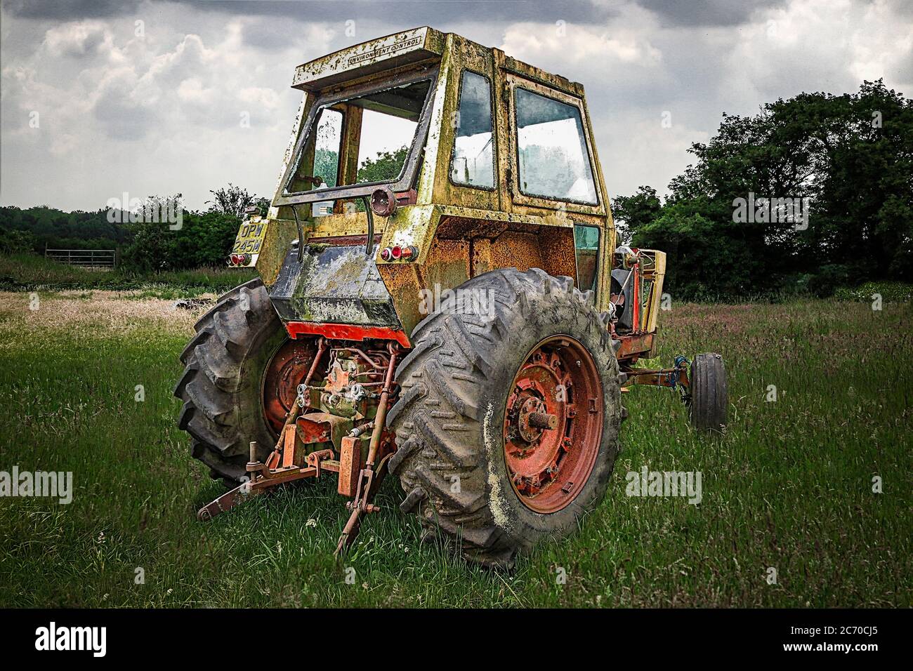 decaying in need or repair american case 970 tractor in field with moody sky Stock Photo