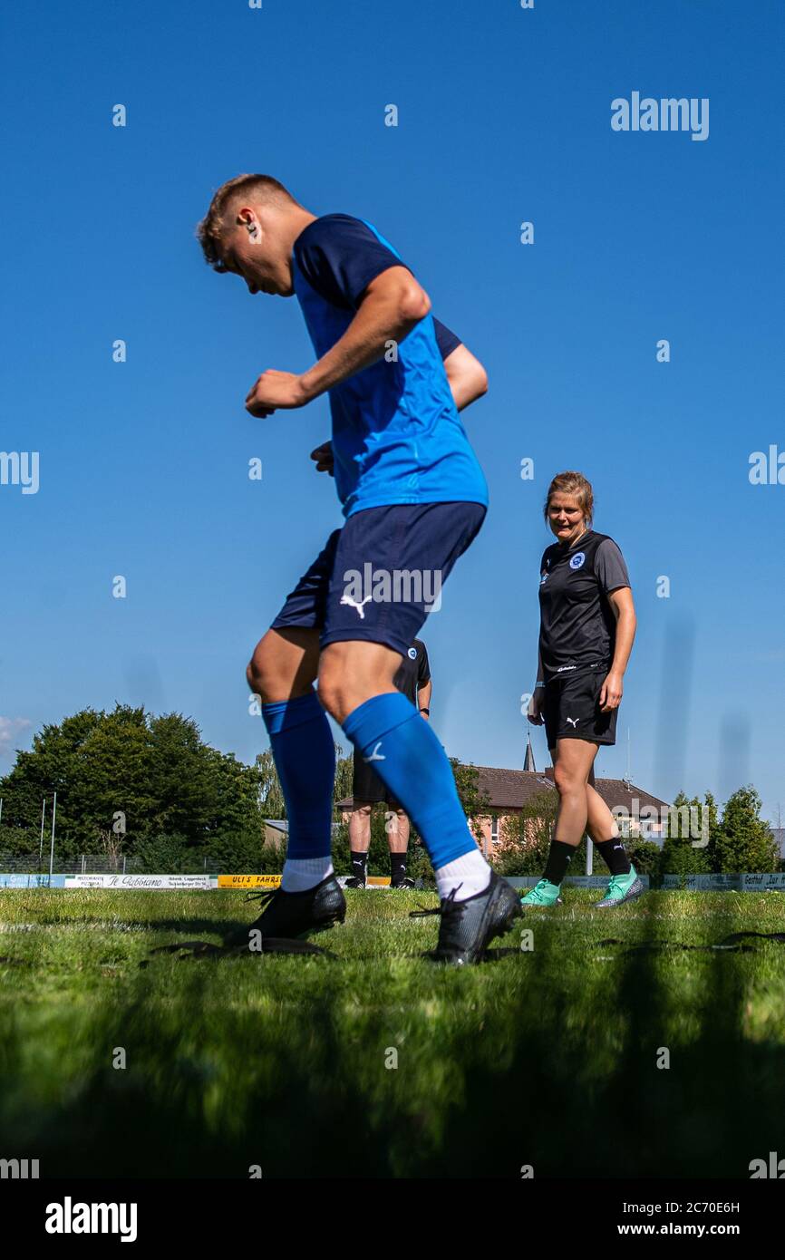 13 July 2020, North Rhine-Westphalia, Lotte: Football, Regionalliga - West: Imke Wübbenhorst (r), coach of Sportfreunde Lotte, watches her players in circuit training during their first training session. Photo: Guido Kirchner/dpa Stock Photo