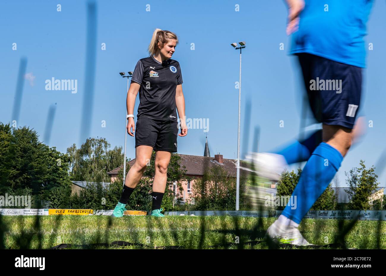 13 July 2020, North Rhine-Westphalia, Lotte: Football, Regionalliga - West: Imke Wübbenhorst (l), coach of Sportfreunde Lotte, watches her players in circuit training during their first training session. Photo: Guido Kirchner/dpa Stock Photo