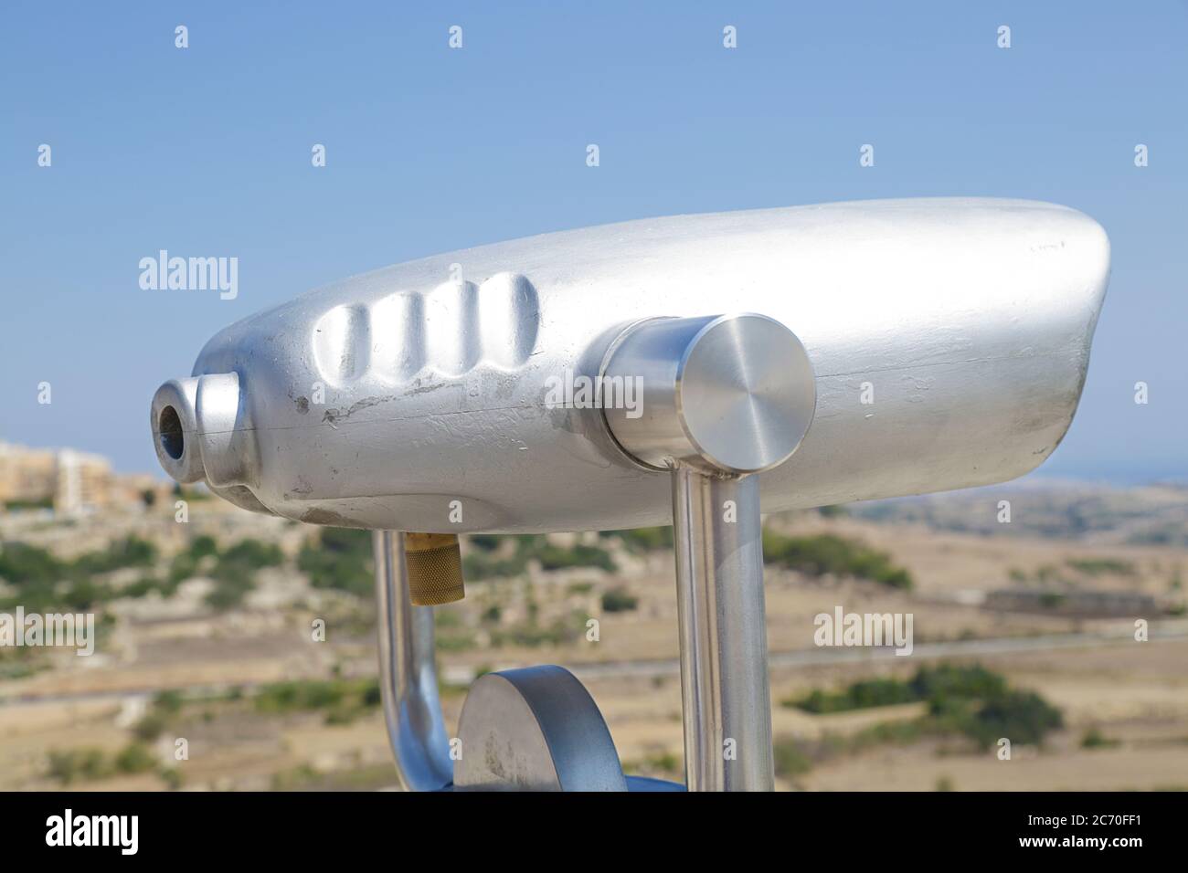 In the foreground a coin operated telescope in the background a view of