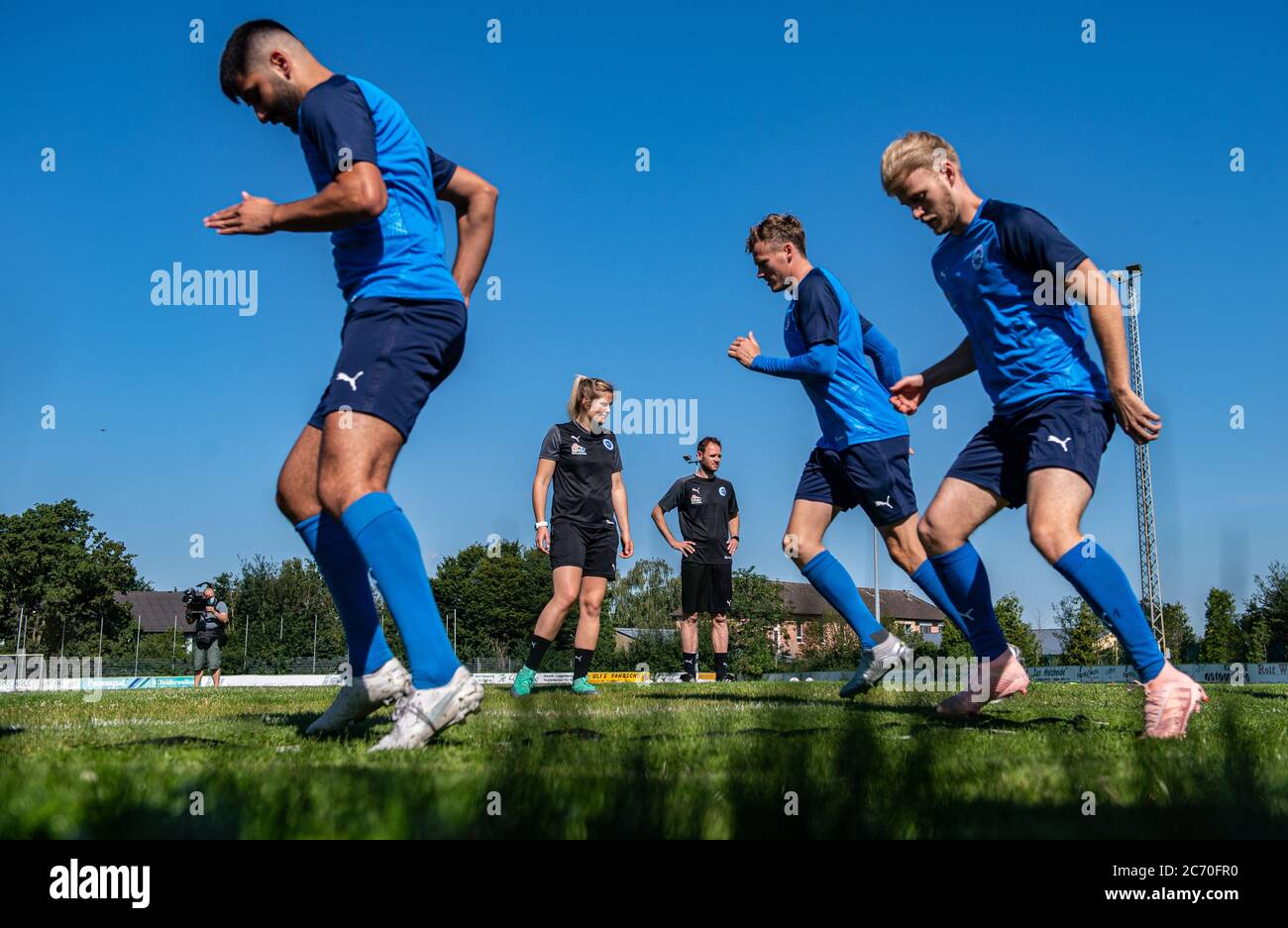 Lotte, Germany. 13th July, 2020. Football, Regional League - West: Imke Wübbenhorst (2nd from left), coach of Sportfreunde Lotte and her co-coach Andy Steinmann (3rd from left) watch their players in circuit training during their first training session. Credit: Guido Kirchner/dpa/Alamy Live News Stock Photo