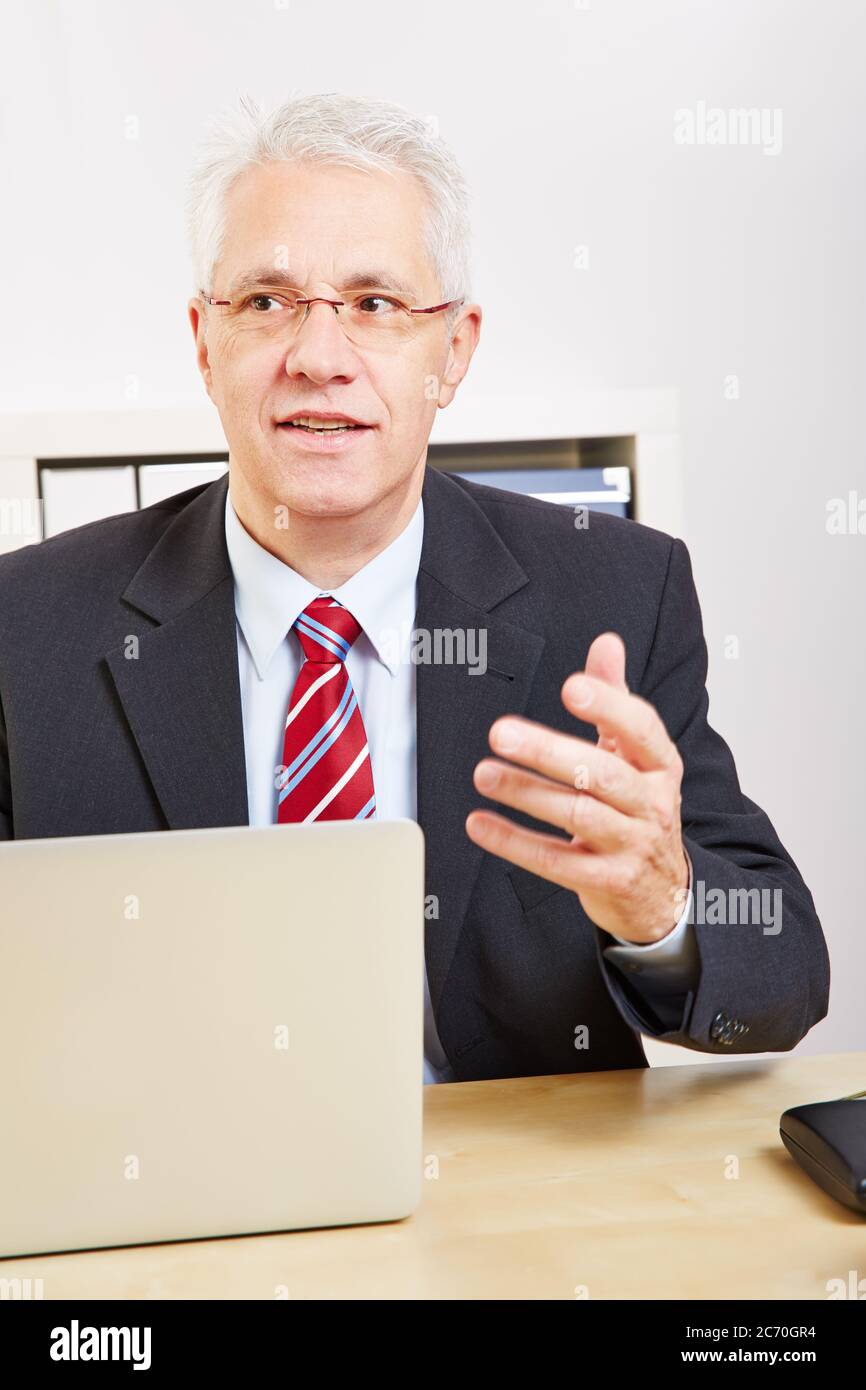 Businessman using laptop at desk makes a proposal Stock Photo