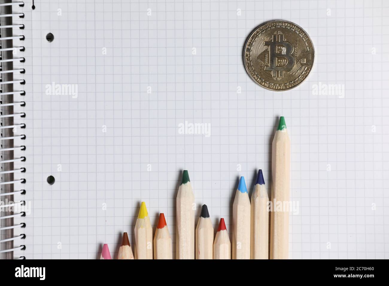 Imaginary bitcoin chart shown with color pencils on a white notebook. Cryptocurrency trading and investment. Stock Photo