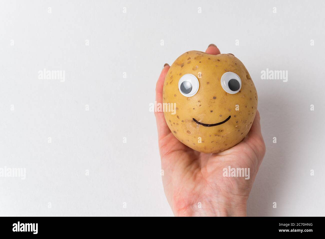 Funny Potato With Eyes And Painted Smile Is On The Hand On White Background Stock Photo Alamy