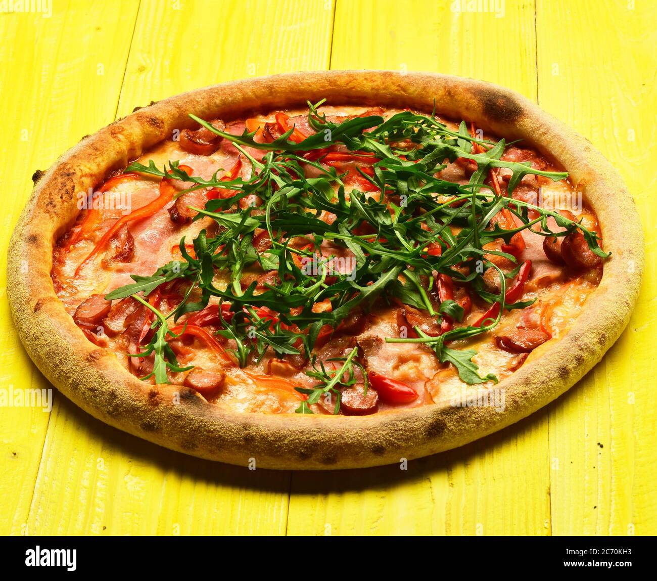 Spicy pizza with rucola and seasoning. Pizza with bacon, cheese and