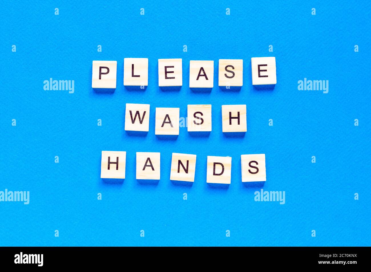 please wash your hands, written in wooden letters on a blue background, warning, request, flat layout, top view, Stock Photo