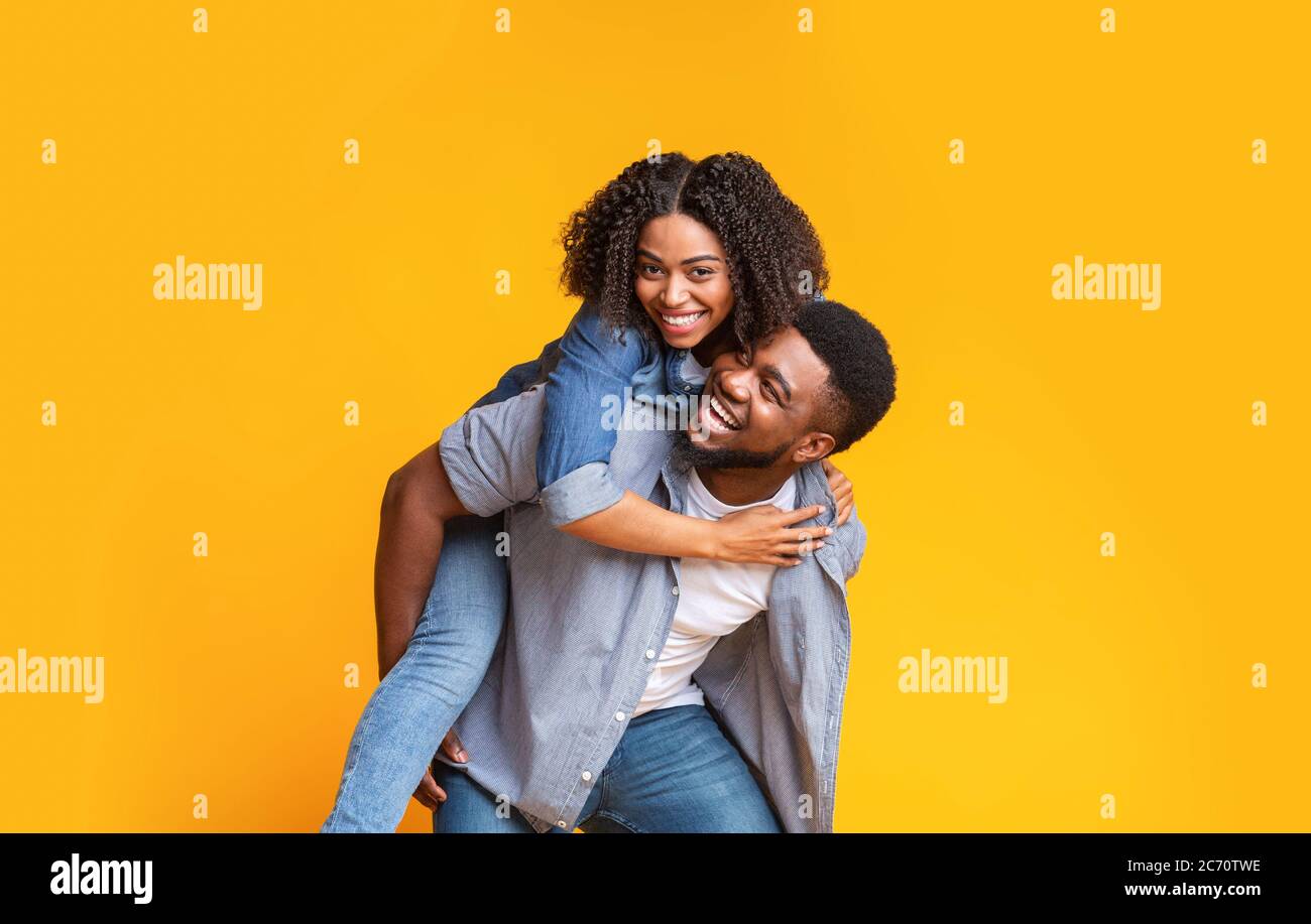 Cheerful African Couple Having Fun Together, Guy Piggybacking His Girlfriend Stock Photo