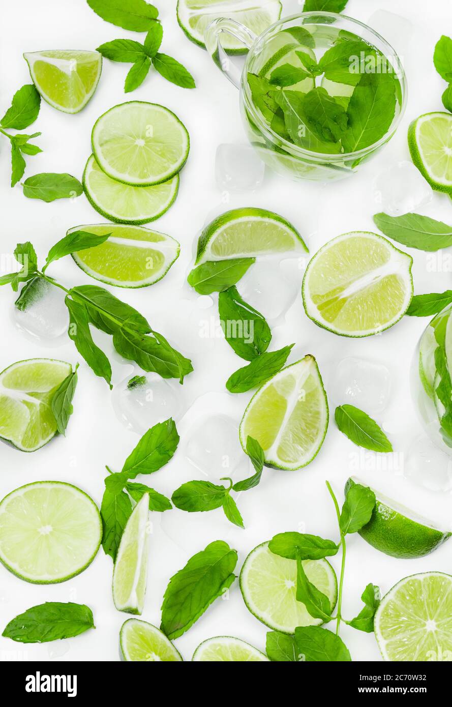 Limes, fresh mint and ice for mojito on white background. Stock Photo