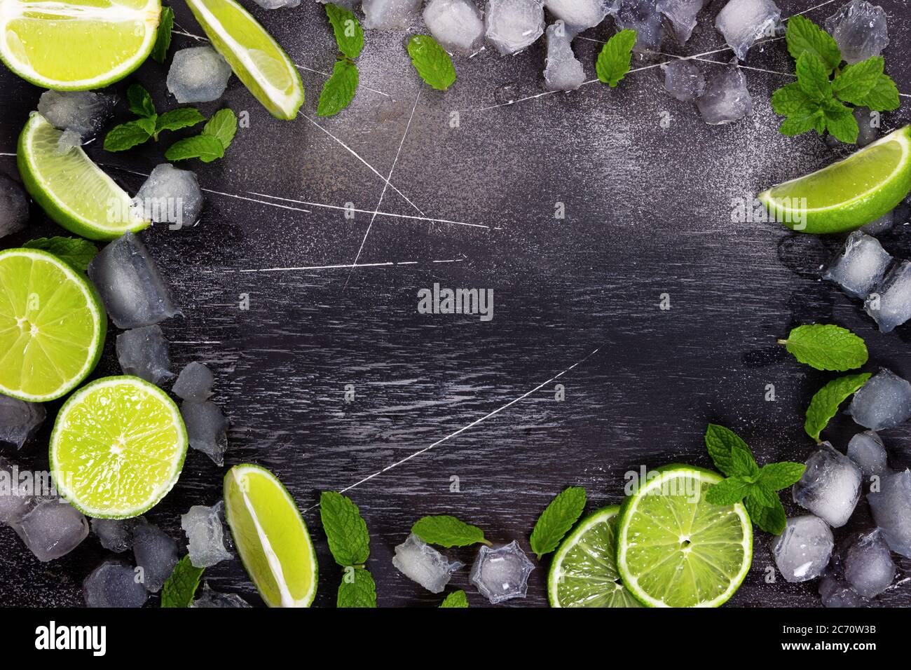 Fresh lime, mint and ice on dark background. Ingredients for Mojito or Cocktail. Top view Stock Photo