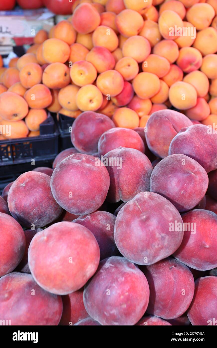 Peaches, nectarines and apricots on a market. Fruits pattern, vertical Stock Photo