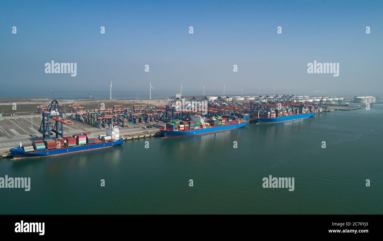 Huge cranes and ships anchored at harbor. International commercial port Stock Photo