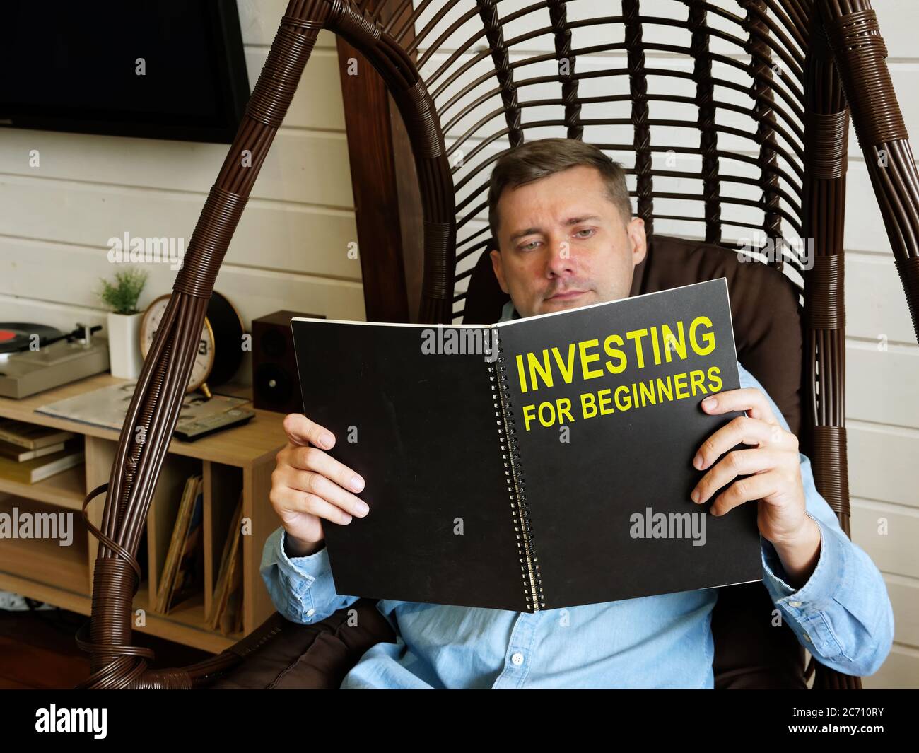 Man reads investing for beginners at home. Stock Photo