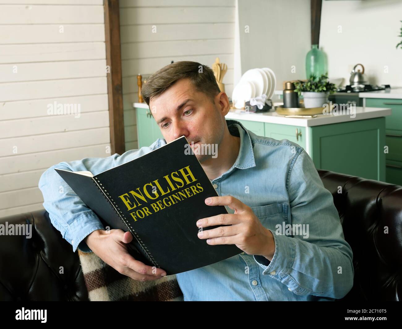 Man learning with English for beginners book. Stock Photo