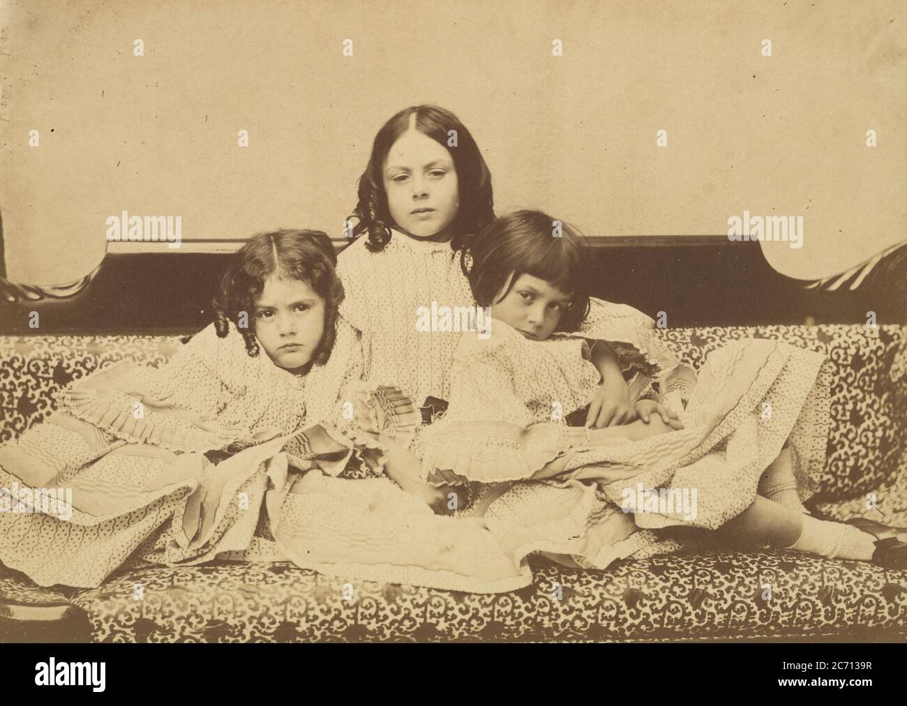 Edith, Ina and Alice Liddell on a Sofa, Summer 1858. Stock Photo