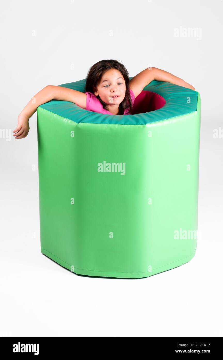 Indoor playground  Young girl in a foam rubber barrel On white Background Stock Photo