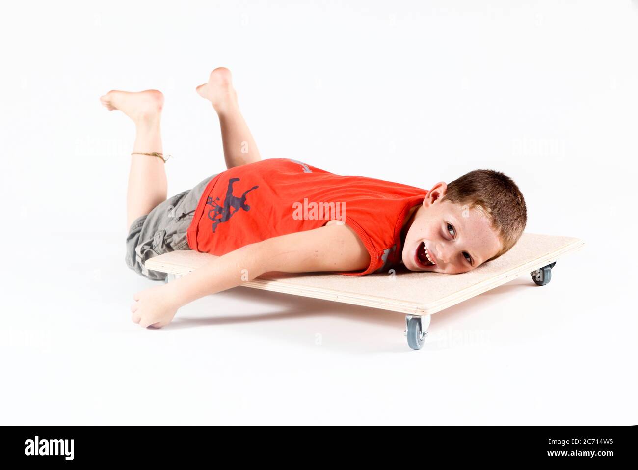 Indoor playground boy plays on wheeled board On white Background Stock Photo