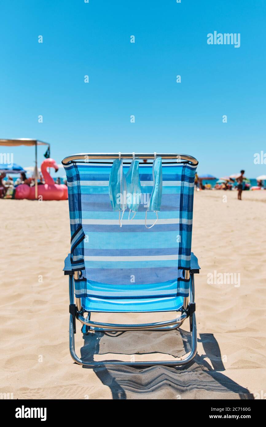 Some Surgical Masks Hanging On A Blue Deck Chair On The Beach With The Sea In The Background Stock Photo Alamy