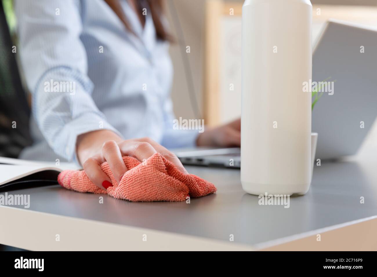 Women disinfecting workplace. New normal concept. Stock Photo