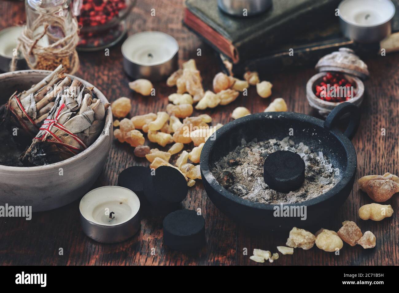 Many little peaces of light yellow Yemen frankincense resin incense on dark  wooden table. Charcoal disk in black holder, candles, sage smudge sticks  Stock Photo - Alamy