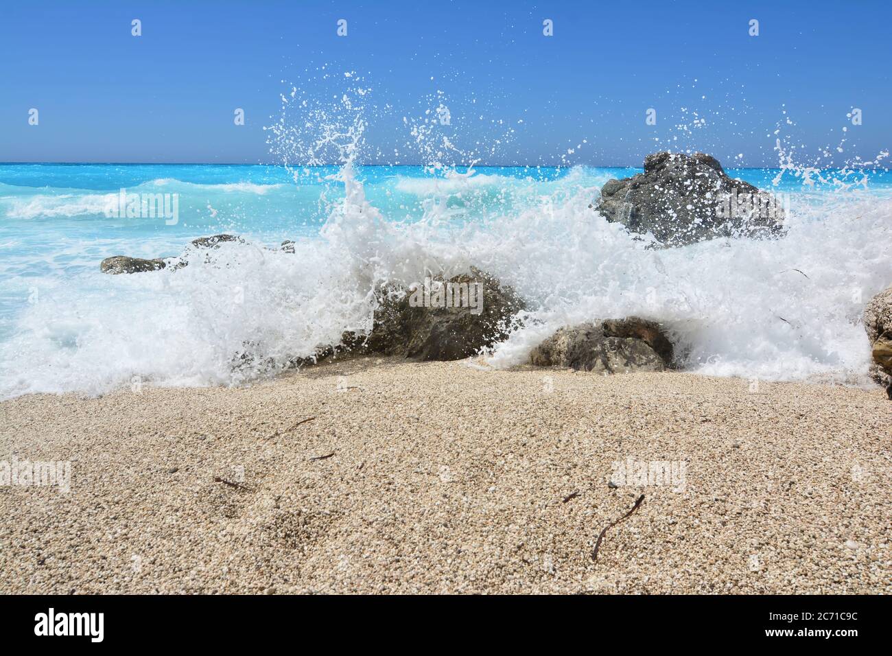 White splash over rocks and pebbles, the last game of the waves before the sea calms down after the storm, Kathisma beach, Lefkada, Greece Stock Photo