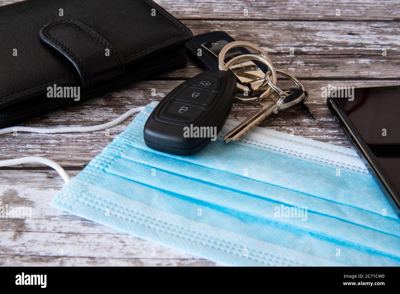 House and car keys, wallet, mobile phone and face mask on wooden surface.  Ready to go out in the new world Stock Photo - Alamy