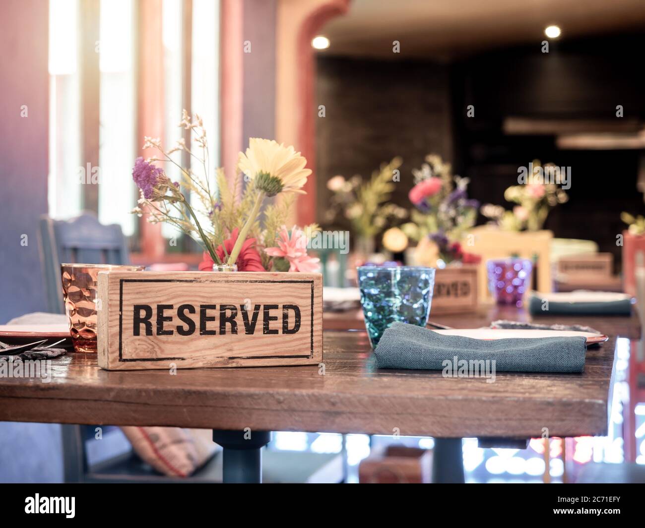 Wooden Reserved Sign Standing With Glass And Flower Pot On Dining Table In Retro Style Restaurant Stock Photo Alamy