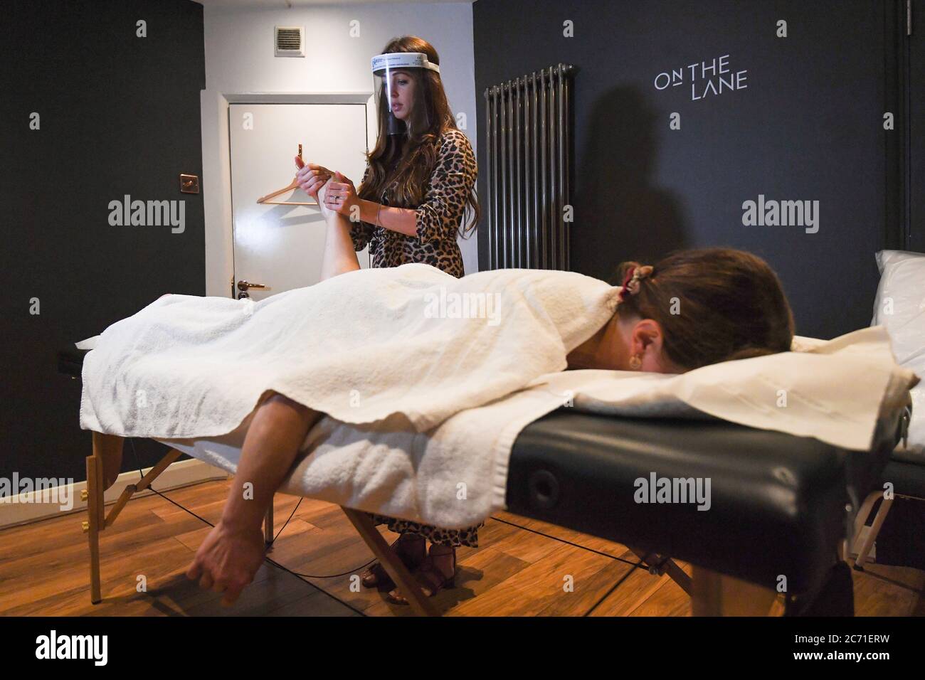 Facialist Taryn Williams massages client Annie Geurard at Taryn Aesthetics at On The Lane beauty salon in Belsize Park, London, as they reopen to customers following the easing of lockdown restrictions in England. Stock Photo