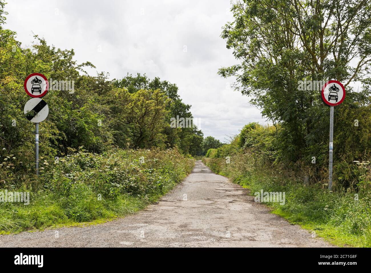 A no motor vehicle sign with a national speed limit sign on a country lane, UK Stock Photo