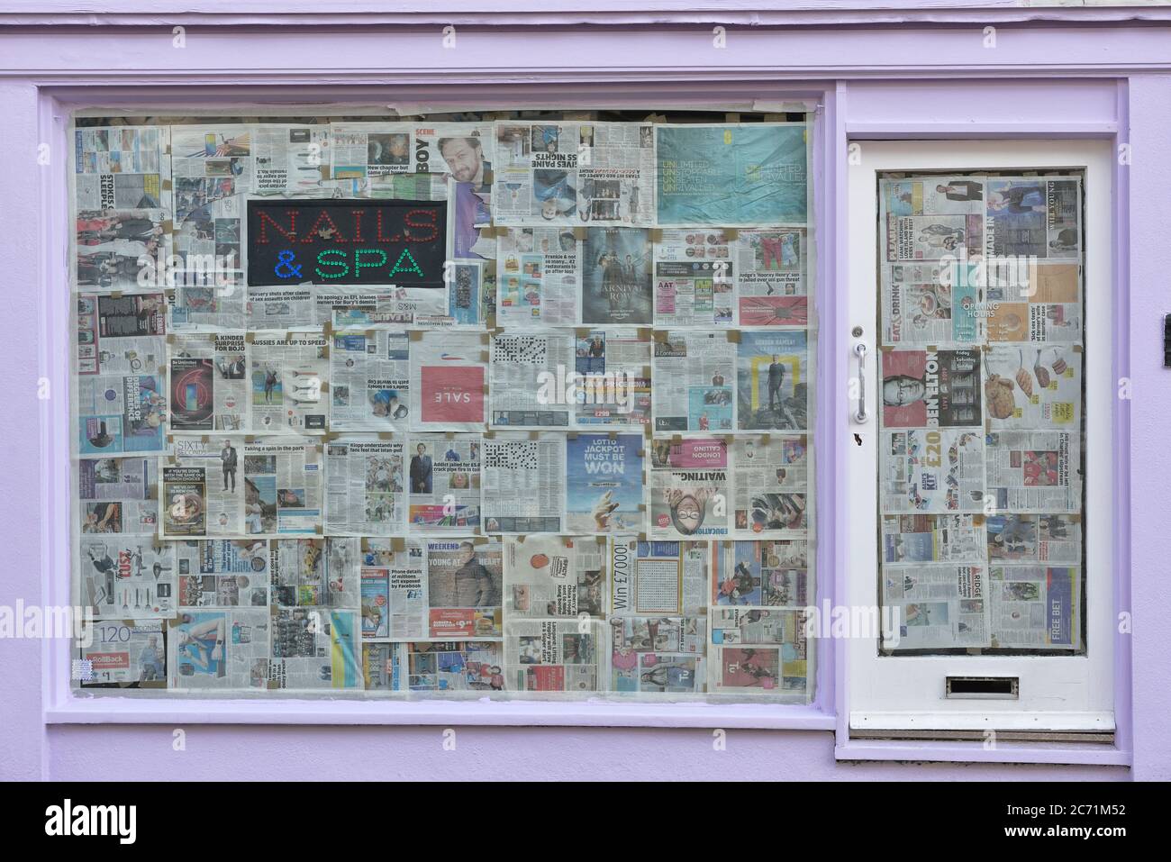 Closed down Nails & Spa bar, salon with Windows covered in Newspaper Hastings, East Sussex, England, UK Stock Photo