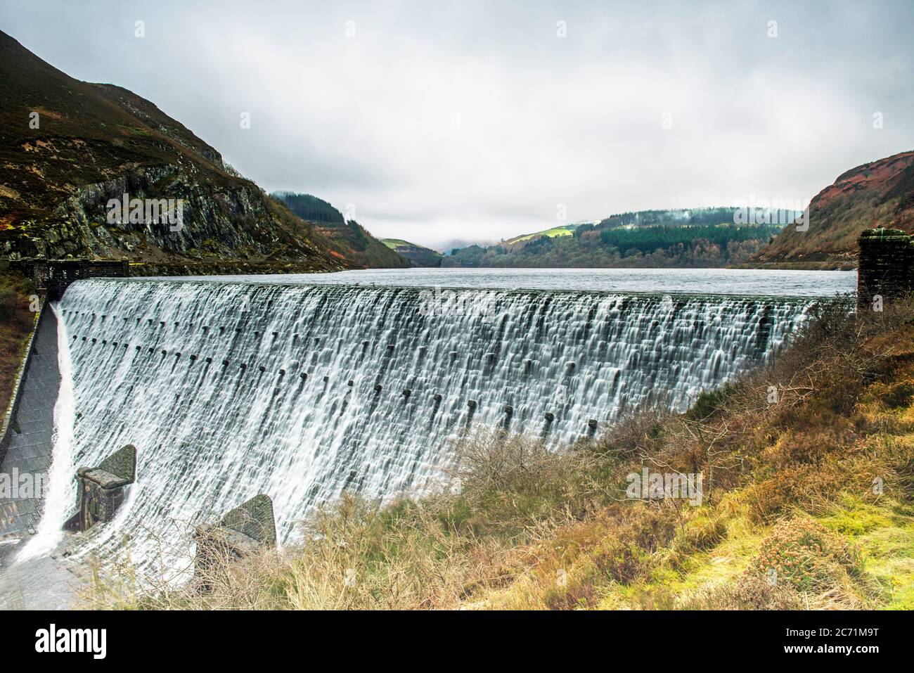Water cascading over the top of the Caban Coch Dam in the Elan Valley, Powys, Mid Wales.. Stock Photo