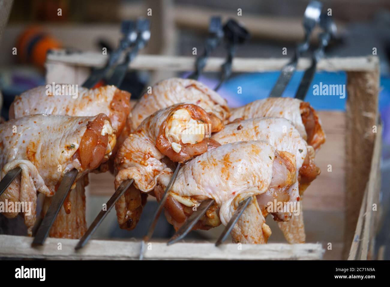 Close-up of chicken legs strung on skewers and ready to cook, selective focus Stock Photo
