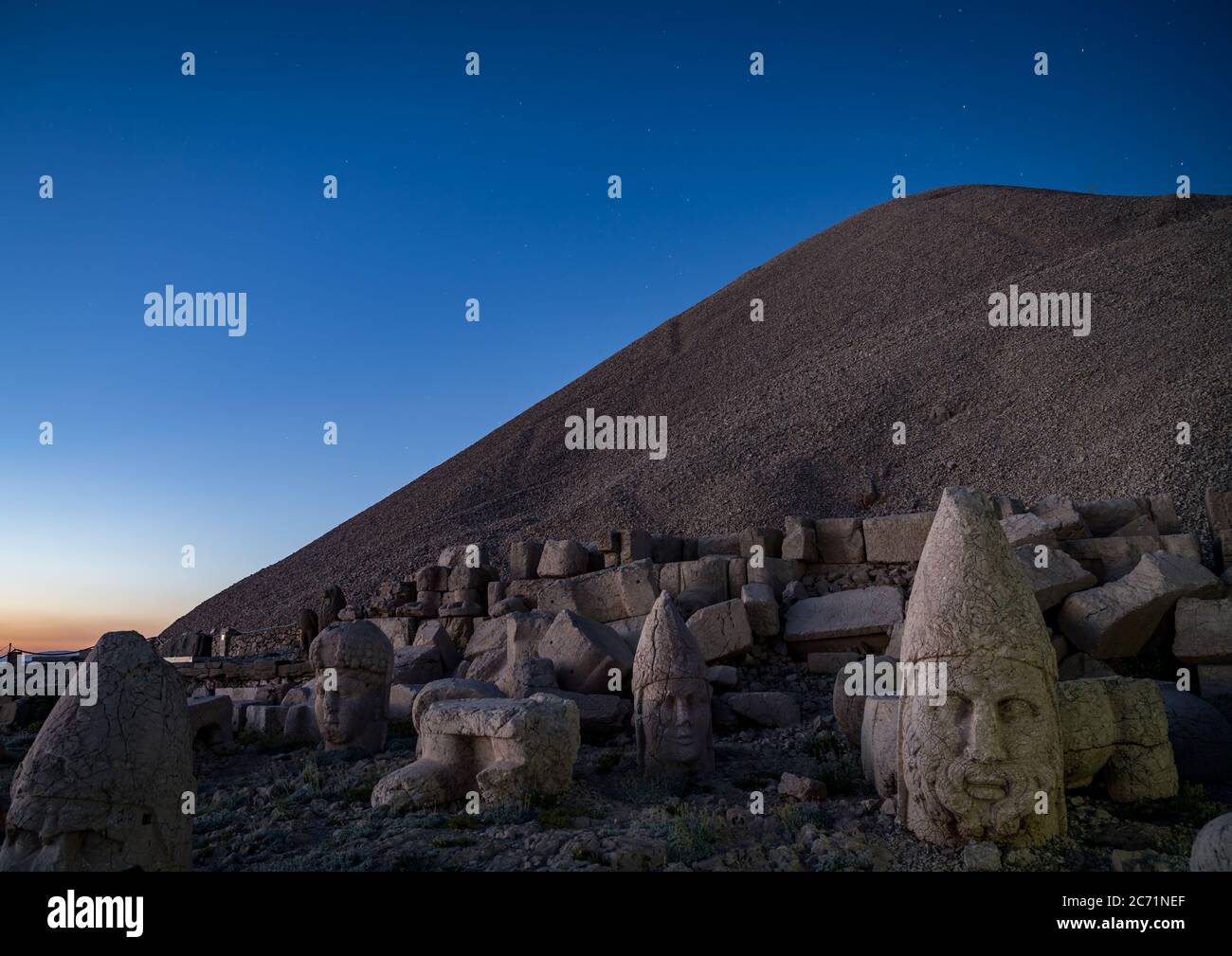 Commagene statues on the summit of Mount Nemrut during sunset with stars in the sky, Adiyaman, Turkey. Stone heads at the top of 2150 meters high Moun Stock Photo