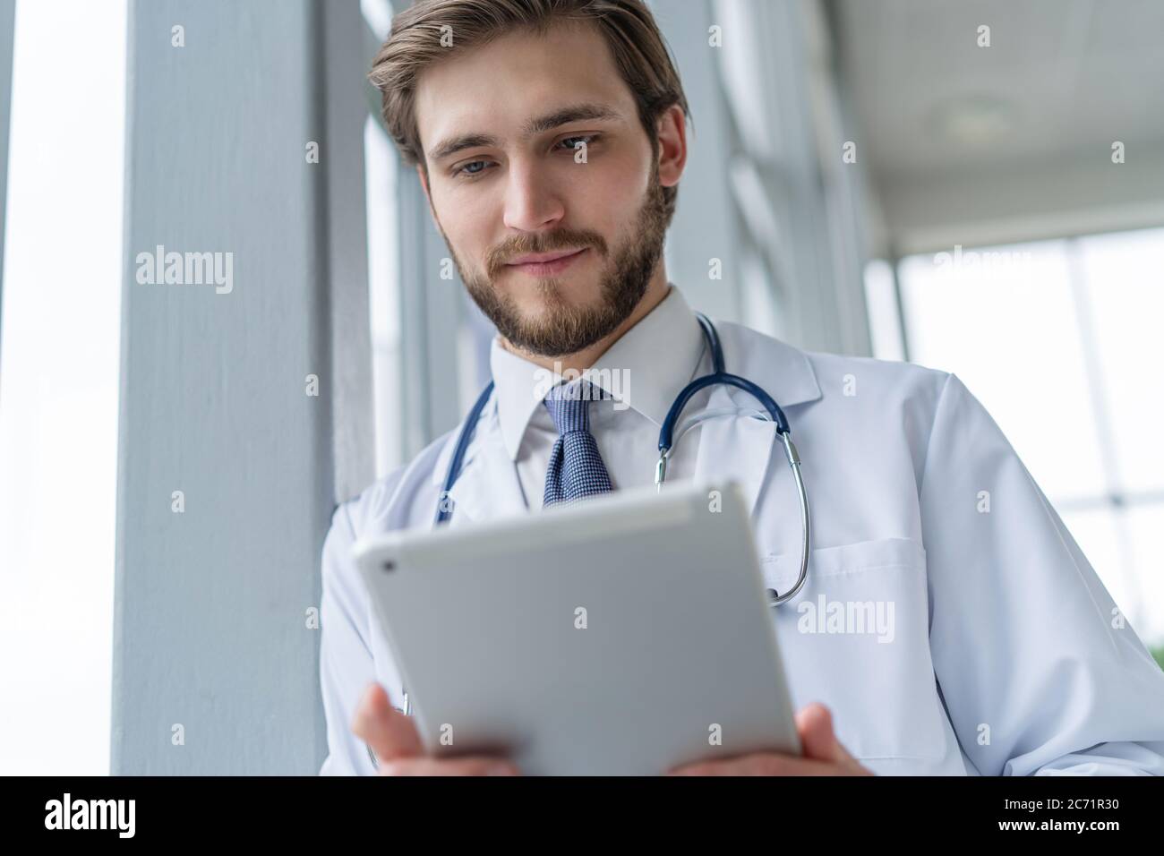 male medical doctor using tablet computer in hospital Stock Photo - Alamy