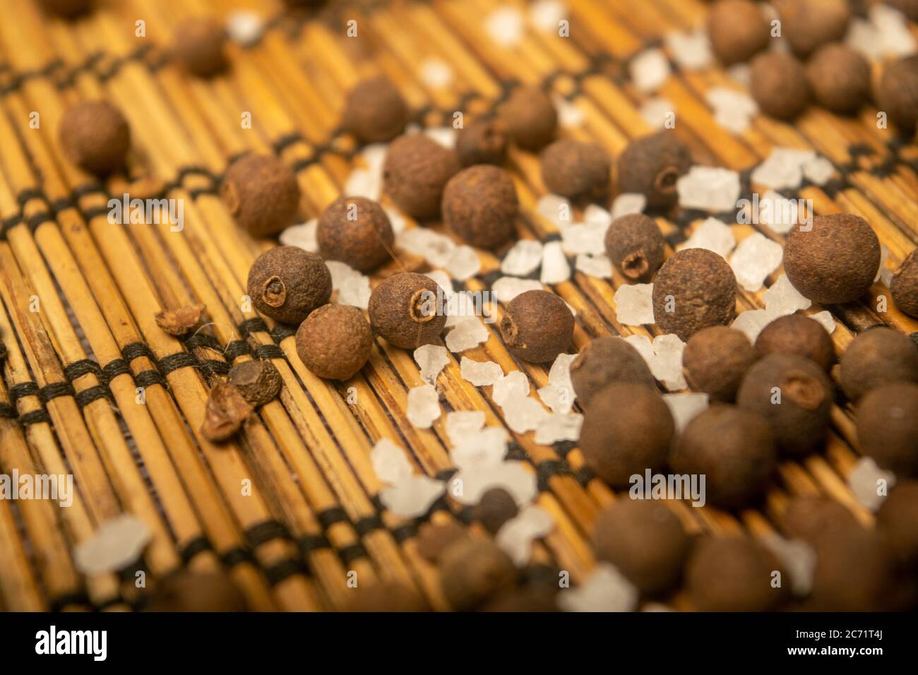 Fragrant black pepper and coarse sea salt in bulk on a reed Mat. Close up Stock Photo