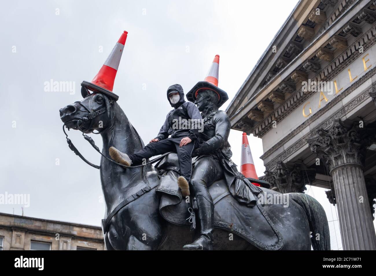 images Duke Of Wellington Statue Glasgow Face Mask https www alamy com glasgow scotland uk 13thjuly 2020 a young man wearing a face mask climbs up the side of the duke of wellington statue to place three traffic cones on the duke and his horse copenhagen credit skullyalamy live news image365762069 html