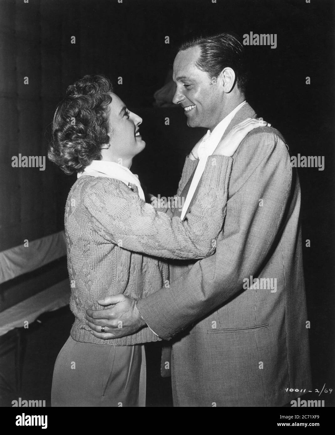 WILLIAM HOLDEN visits BARBARA STANWYCK on set candid during filming of THE FILE ON THELMA JORDAN 1949 director ROBERT SIODMAK producer HAL B. WALLIS  Wallis - Hazen / Paramount Pictures Stock Photo