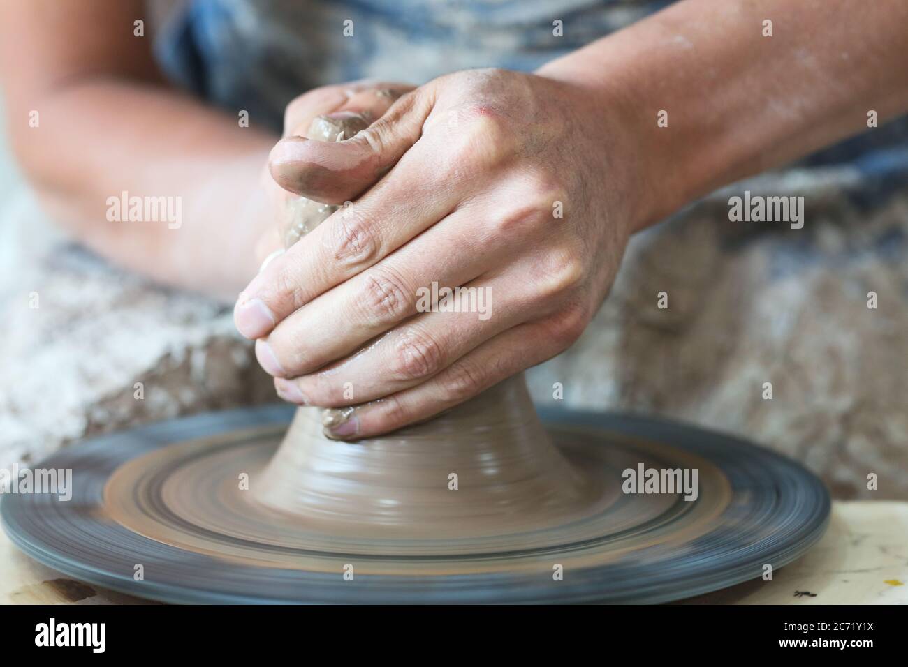 Potter hands making in clay on pottery wheel. Potter makes on the