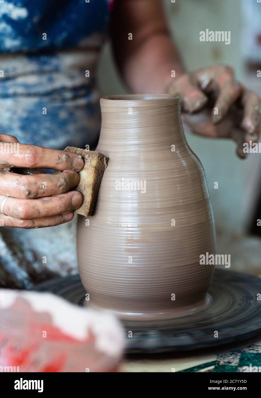 Potter hands making in clay on pottery wheel. Potter makes on the pottery wheel Stock Photo