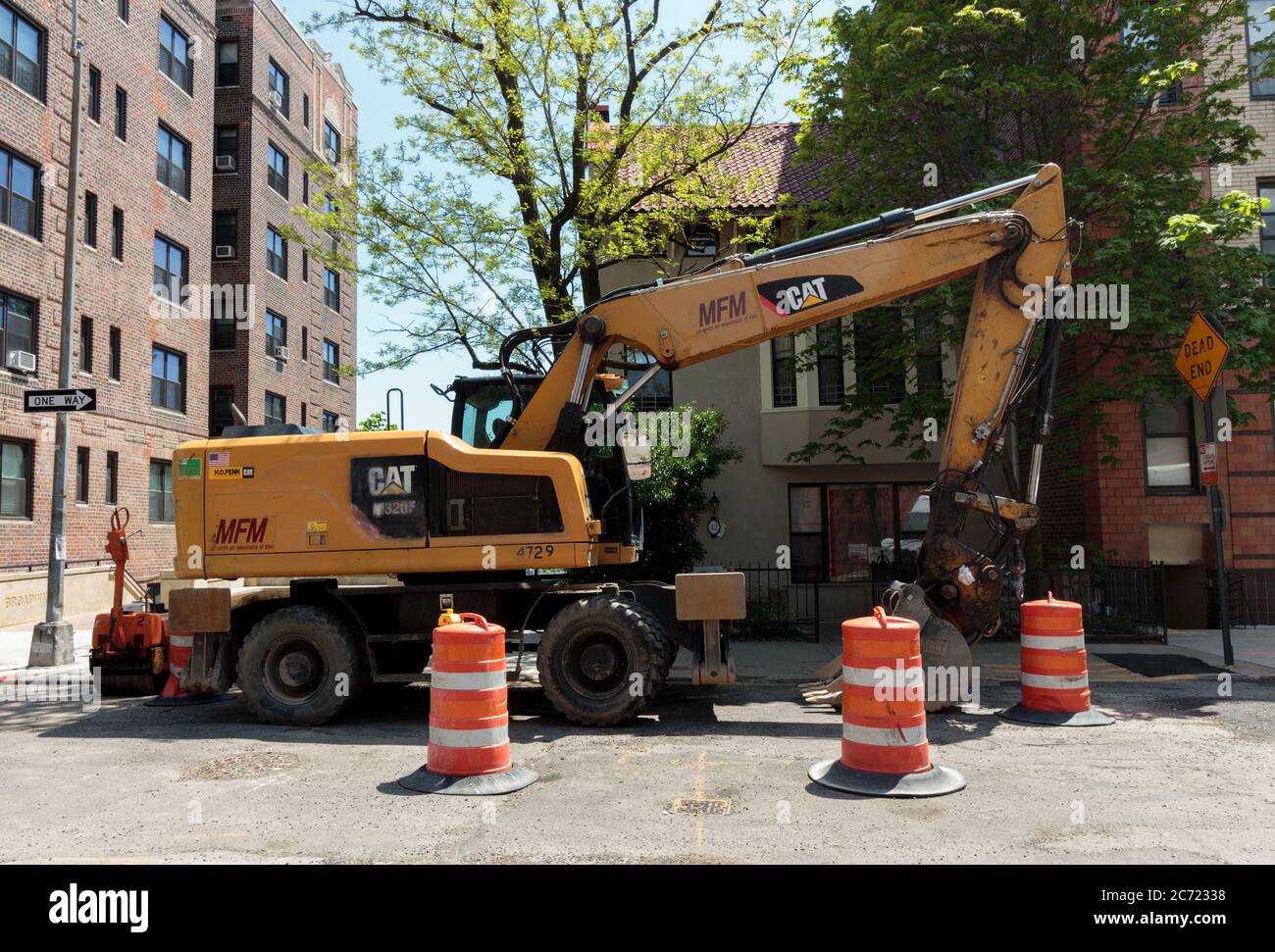 Caterpillar brand bulldozer shovel truck parked on a new york street while being used by the city for work. Stock Photo