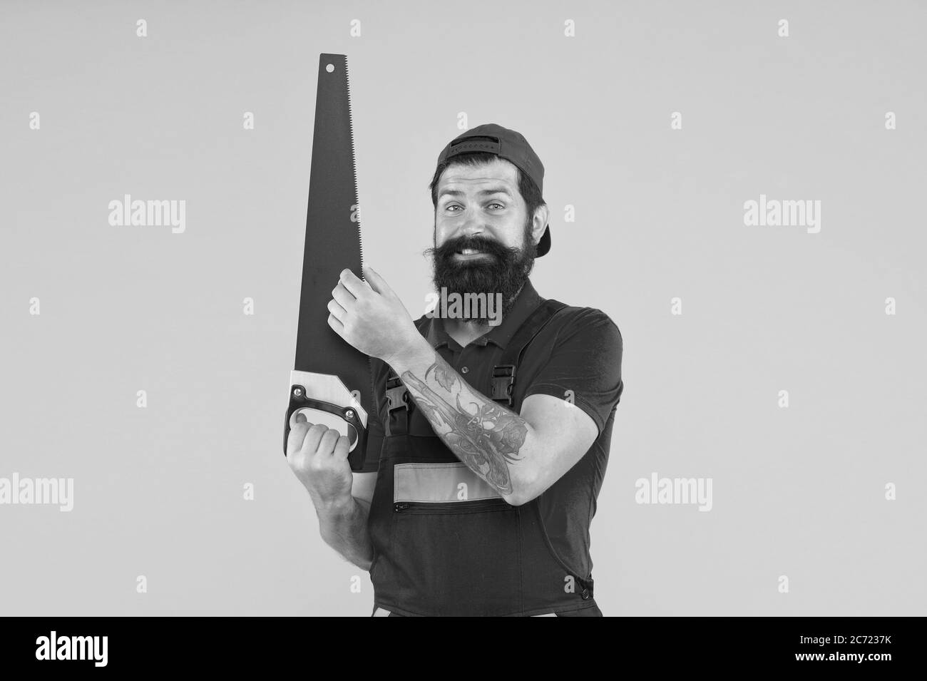 Safety measures. Man hold handsaw in hand. Carpentry works. Repair wooden objects. Carpentry service. Carpentry workshop concept. Professional tools. Builder worker carpenter handyman hold saw. Stock Photo