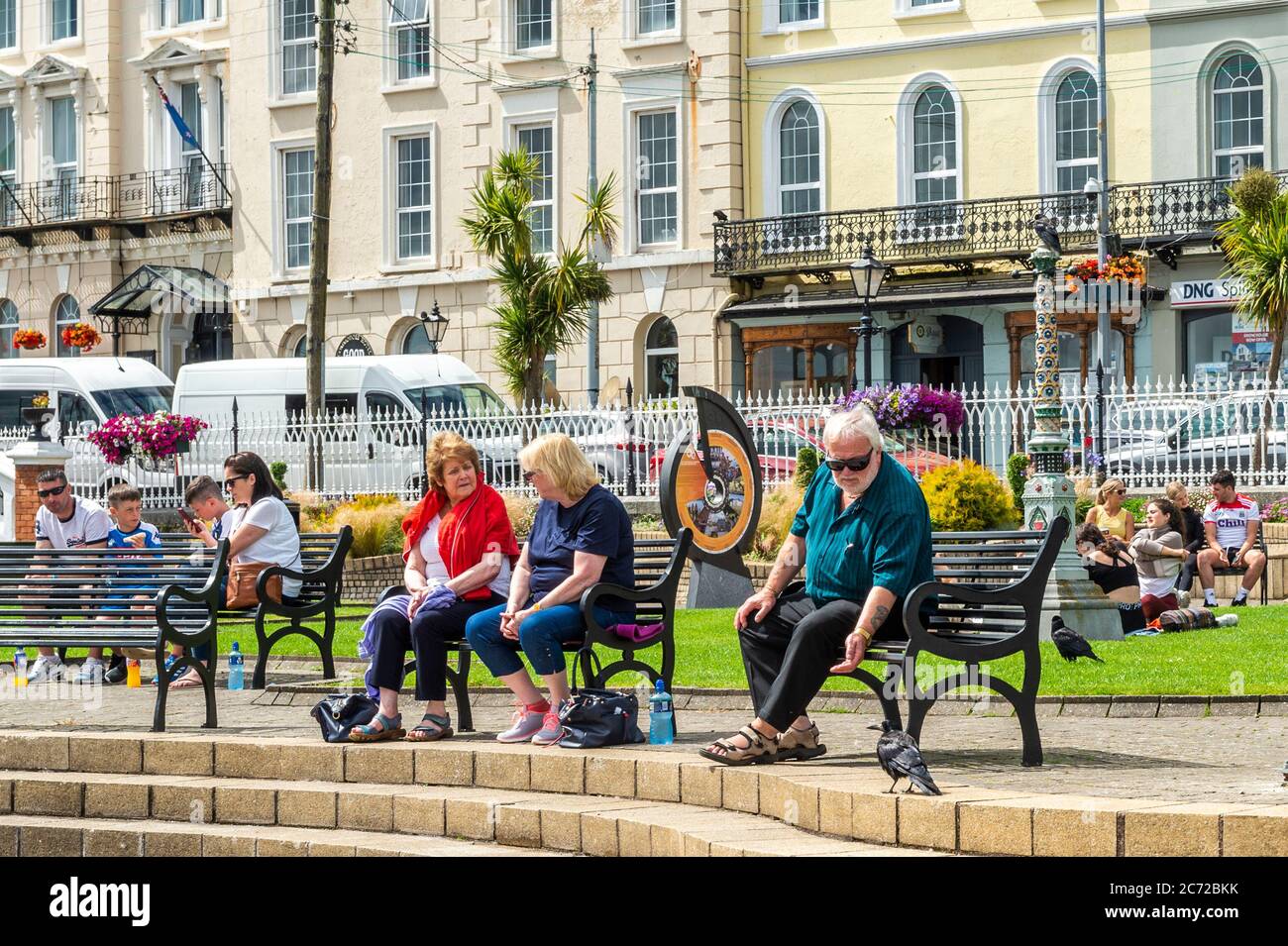 Cobh, County Cork, Ireland. 13th July, 2020. On an overcast but humid day, people enjoy the President John F. Kennedy Memorial Park on the sea front in Cobh. Credit: AG News/Alamy Live News Stock Photo