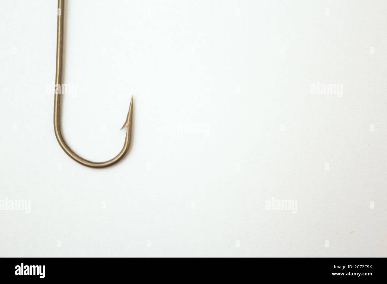 Fishing hook on a white paper background - closeup Stock Photo
